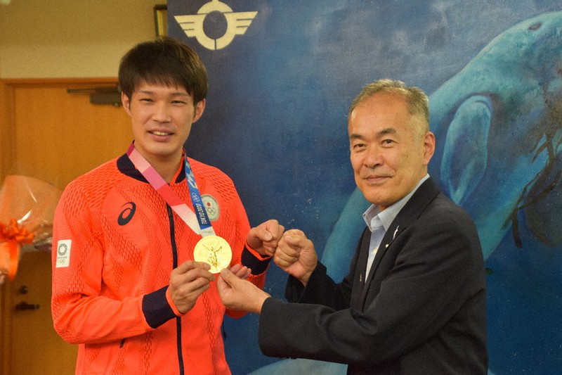 「グータッチ」で山田優選手(左)の健闘をたたえる中村欣一郎・三重県鳥羽市長=同市役所で2021年8月18日、尾崎稔裕撮影