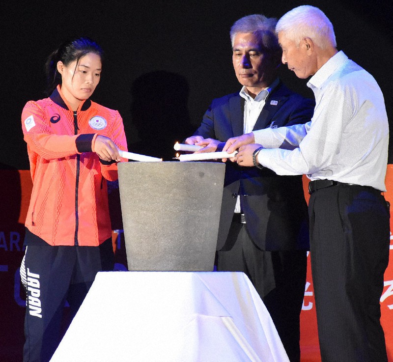 火皿へ火を移す錦織えみさん(左)と福井幸夫理事長(右)ら=松江市学園南1のくにびきメッセで、松原隼斗撮影