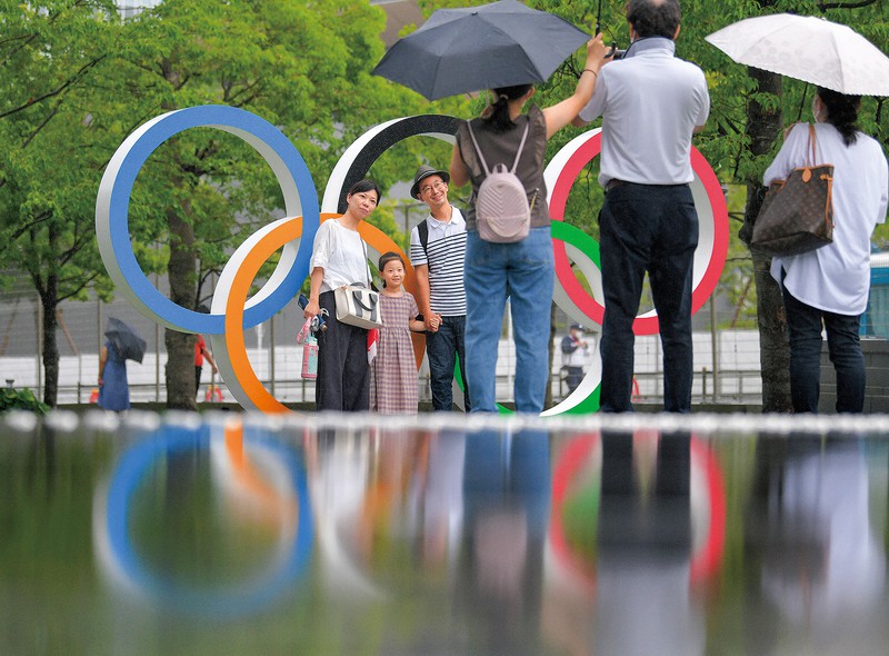 東京五輪の閉幕から一夜明け、五輪シンボルマークの前で記念撮影する人たち