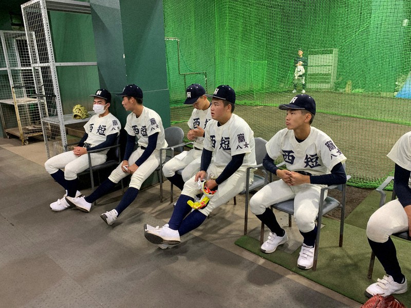 球場裏で待機する西短大付の選手ら=西短大付提供