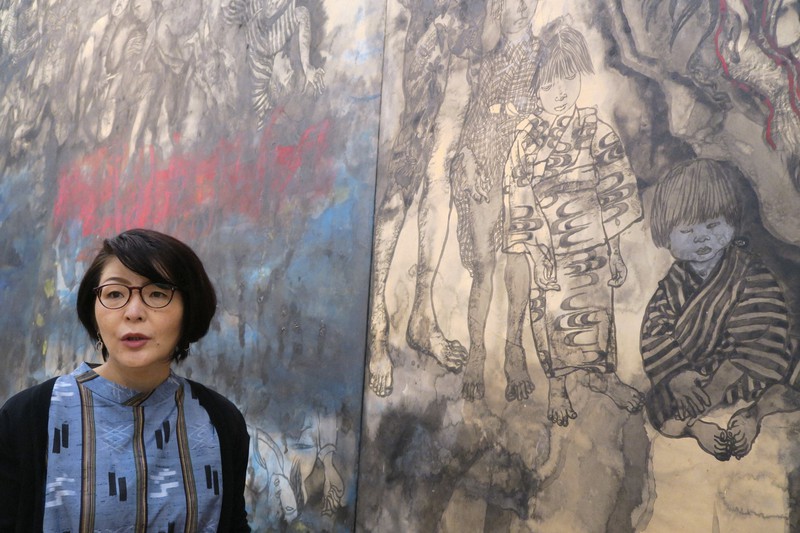 「沖縄戦の図」の前で丸木夫妻の制作意図を語る上間かな恵さん=沖縄県宜野湾市の佐喜眞美術館で8月11日、嬉野京子さん撮影