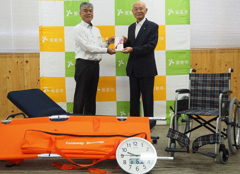 有吉市長(右)に寄贈品の目録を手渡す香月副委員長