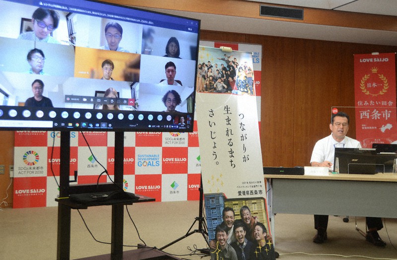 オンラインで大学院生らと移住政策などについて意見をやりとりする玉井敏久市長(右)=愛媛県西条市役所で、山中宏之撮影