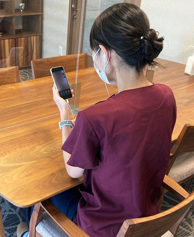 スマートフォンを使い、オンラインで自宅療養者を診療する平郁会の大田和枝理事長=同会提供(画像の一部を加工しています)