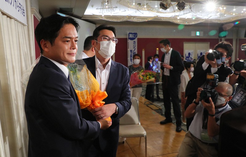 横浜市長選で当選確実となり、支援者から花束を受け取る山中竹春氏(左)=横浜市中区で2021年8月22日午後8時32分、長谷川直亮撮影