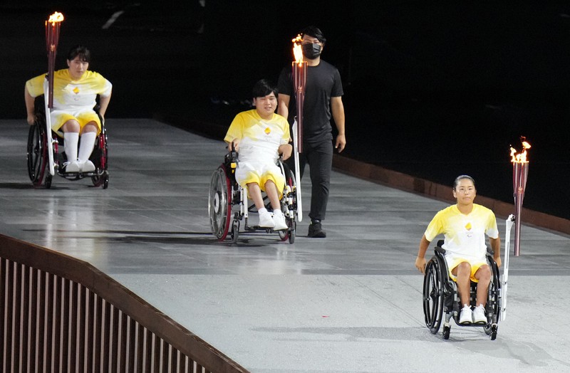 開会式で聖火を運ぶリレー最終走者の(手前から)上地結衣、内田峻介、森崎可林=東京・国立競技場で2021年8月24日午後10時47分、佐々木順一撮影