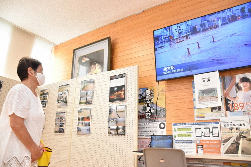紀伊半島豪雨災害発生時の映像や写真の展示に見入る来庁者=和歌山県新宮市役所で、木村綾撮影
