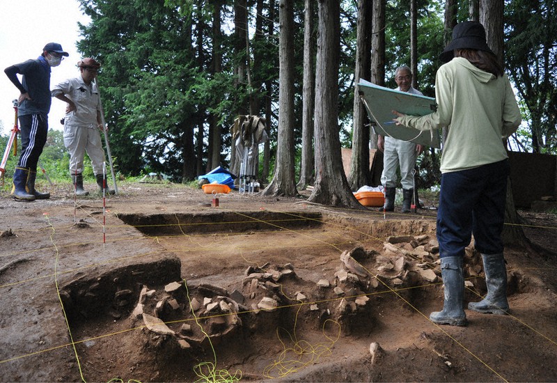 後円部の墳頂部分で見つかった埴輪列(手前)を計測する福島大の学生ら=福島県須賀川市日照田の団子山古墳で2021年8月25日、熊田明裕撮影