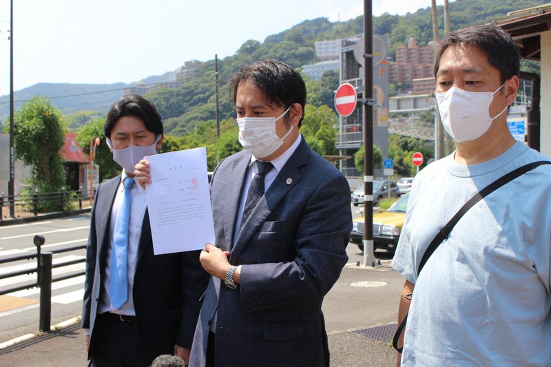 熱海署が受理した告訴状の写しを示して報道陣に説明する弁護団と瀬下雄史さん(右)=静岡県熱海市福道町で2021年8月27日午前10時48分、梁川淑広撮影