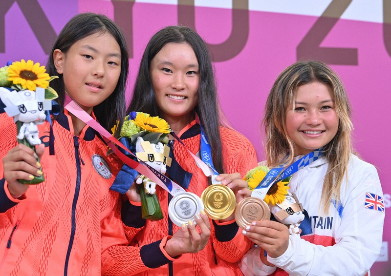 スケートボード女子パーク決勝を終えてメダルを手に撮影に応じる優勝した四十住さくら(中央)。左は2位の開心那、右は3位に入った英国のスカイ・ブラウン=有明アーバンスポーツパークで2021年8月4日、宮間俊樹撮影