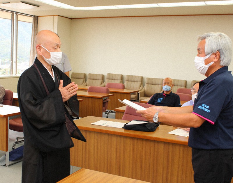 竹仲良広・美浜町議会議長(右)に住民説明会開催の申し入れ書を手渡した小浜市の明通寺住職の中嶌哲演さん=同町役場で、大島秀利撮影