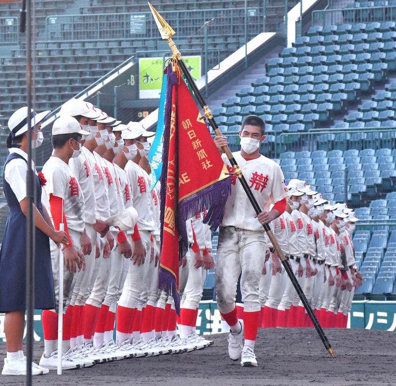 閉会式で優勝旗を受け取り、定位置へ戻る智弁和歌山の宮坂主将。手前は智弁和歌山、右後方は智弁学園の選手たち=平川義之撮影