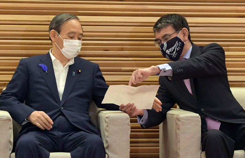 閣議前に資料を手に言葉を交わす菅義偉首相(左)と河野太郎行政改革担当相=首相官邸で2021年7月9日午前10時1分、竹内幹撮影