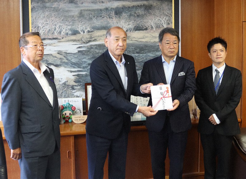 辻村源四郎黒滝村長(中央左)に寄付の目録を渡す「黒滝森物語村」の辰巳繁副社長(中央右)。左端は橋本正博議長、右端は野崎裕太取締役総支配人=黒滝村役場で、堀川剛護撮影