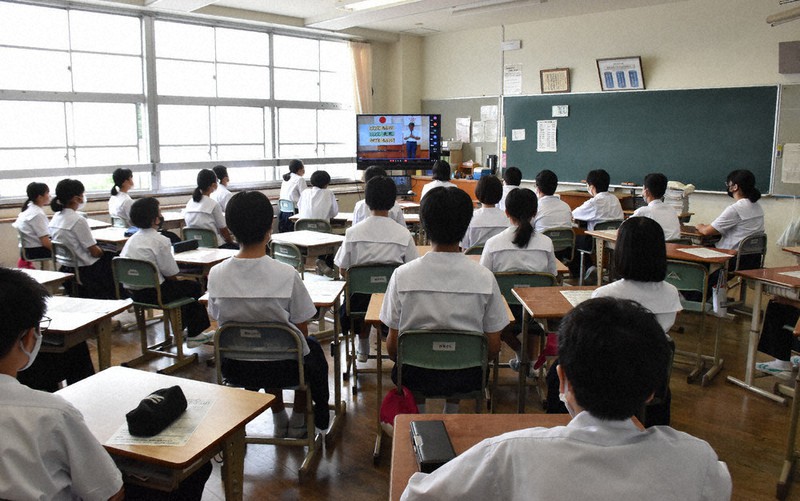 テレビモニターで校長の話を聞く生徒たち