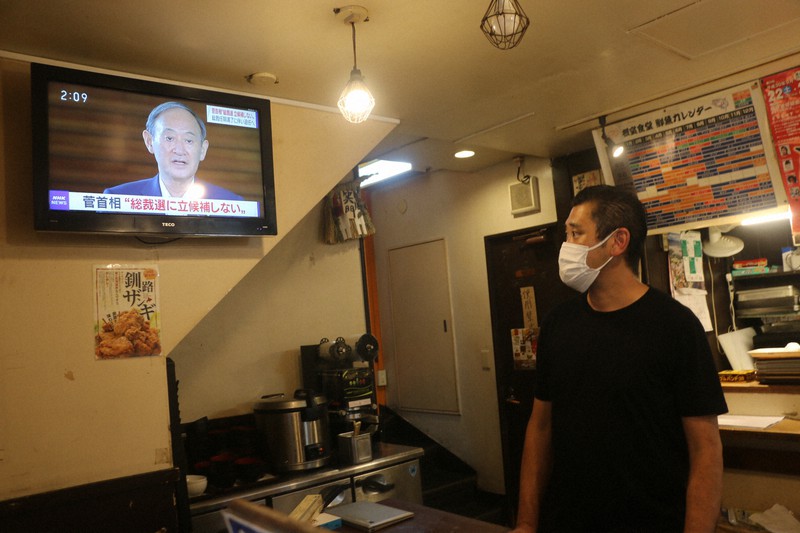 菅義偉首相の自民党総裁選不出馬を伝えるニュースを見つめる根室食堂の平山徳治店長=東京都港区で2021年9月3日午後2時9分、木下翔太郎撮影