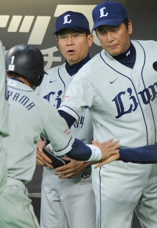 味方の適時打で生還した栗山(手前)を迎え入れる西武監督時代の渡辺GM(右)=札幌ドームで2010年9月26日、木葉健二撮影
