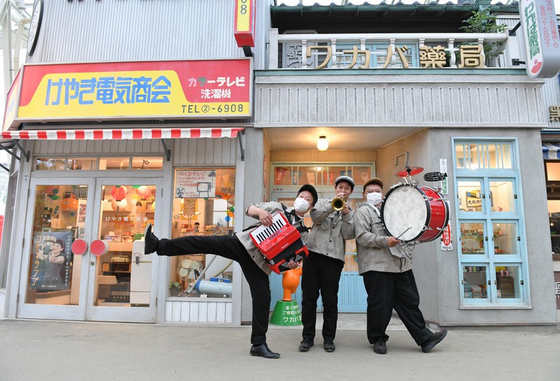 「夕日の丘商店街」で音楽隊としてパフォーマンスを繰り広げるキャストら=埼玉県所沢市の西武園ゆうえんちで2021年5月、北山夏帆撮影