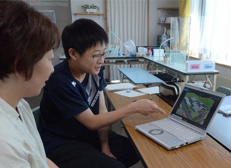 新学校の完成予想図を見ながら語り合う小泉司さん(右)と母、奈津子さん=北海道安平町内で2021年8月21日、平山公崇撮影