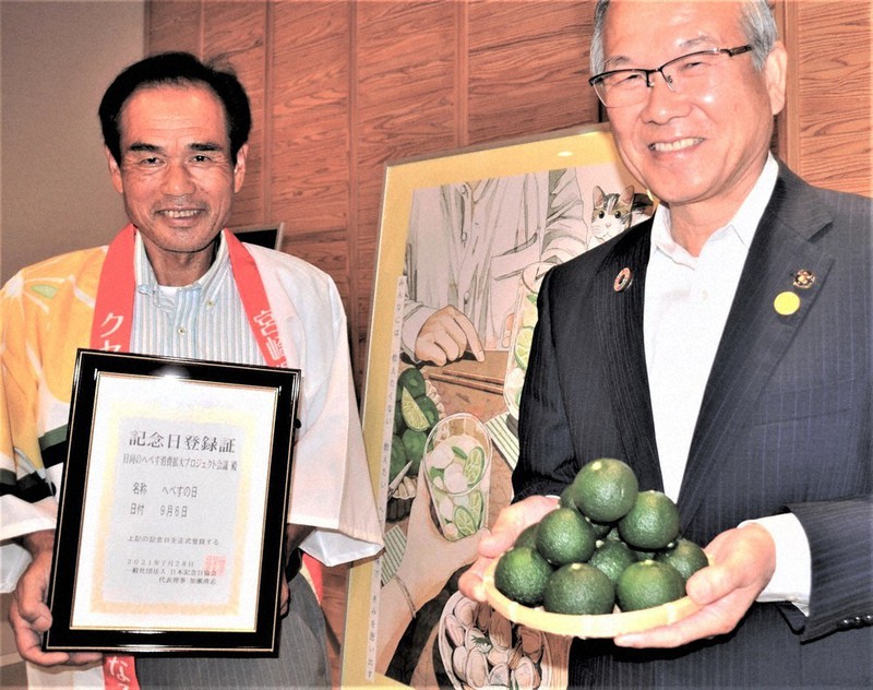 「へべすの日」の登録証を披露する黒木会長(左)とへべすを手にする十屋市長