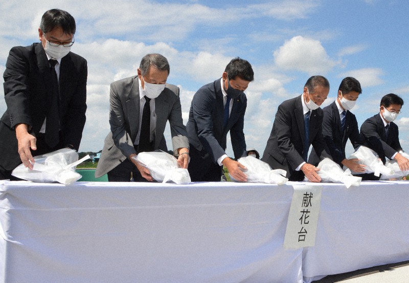 鬼怒川の堤防の決壊場所で献花する神達岳志市長(左から3人目)ら=茨城県常総市三坂町で