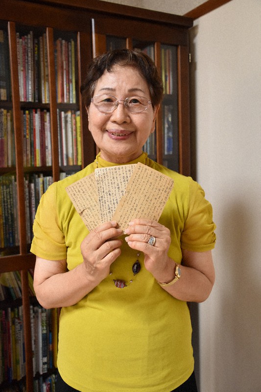 父からのはがきを手にする安藤さん