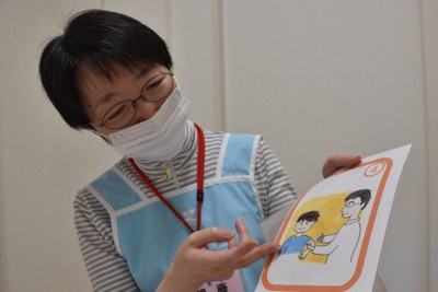 接種の手順を表したイラストを手にする看護師の伊藤舞美さん＝東京都八王子市のはしもと小児科で2021年8月19日午後0時49分、中川友希撮影