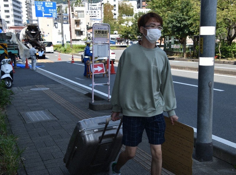 衣服や貴重品などの最小限の荷物を持ち、次の避難先のホテルに移動する徐浩予さん=静岡県熱海市で2021年9月15日、深野麟之介撮影