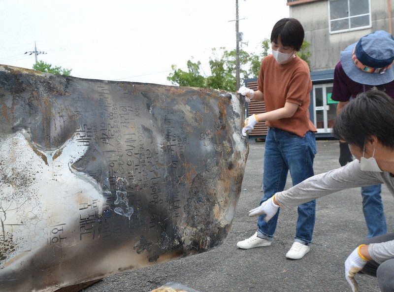 文字の一部が見える形で回収された、セウォル号沈没事故の生存者が製作した看板＝京都府宇治市伊勢田町ウトロで2021年9月12日午後2時1分、鈴木健太郎撮影