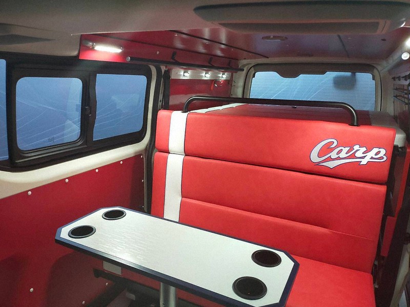 広島カープモデルのキャンピングカー内部。府中家具のテーブル(手前)など内装材のほとんどを広島県内で調達している=広島県福山市芦田町のレクビィ福山工場で