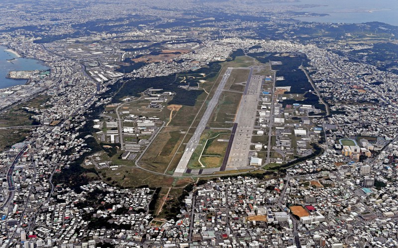 住宅地に囲まれた米軍普天間飛行場(中央)=沖縄県宜野湾市で2018年1月27日、本社機「希望」から野田武撮影