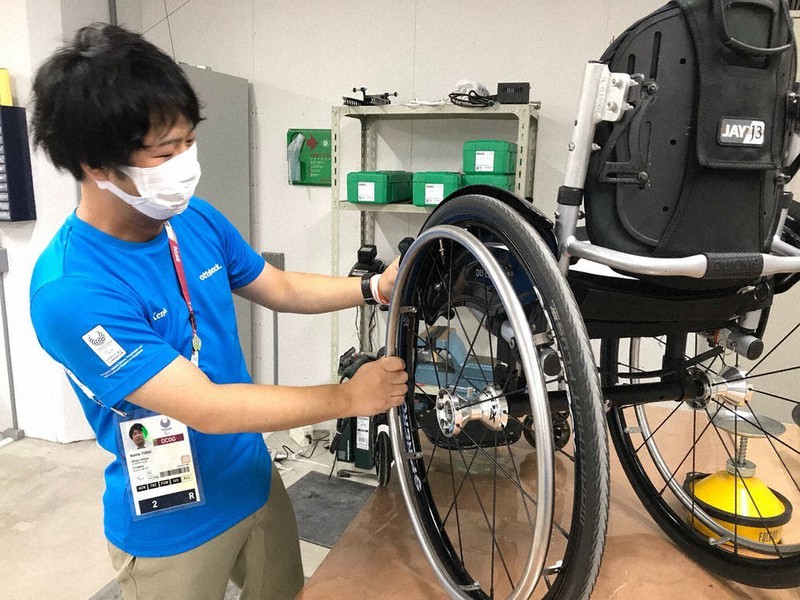 東京パラリンピックの選手村で車椅子の修理をする唐内健太さん=2021年9月2日撮影、唐内さん提供