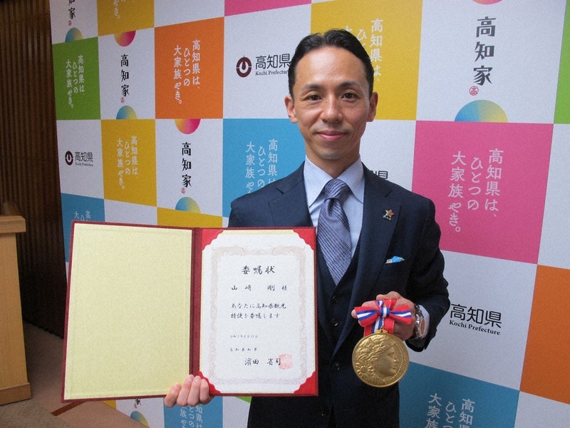 高知県観光特使の委嘱状とバーテンダー日本一の優勝メダルを手にする山崎剛さん=高知県庁で、2021年8月23日午前10時58分、小林理撮影