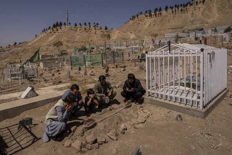 米軍の攻撃で死亡した家族を埋葬した墓地で祈りをささげる遺族=アフガニスタンの首都カブールで2021年9月13日、AP