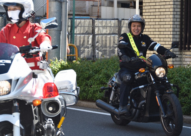 愛車の「ハーレーダビッドソン」に乗って交通安全パレードに参加するノッチさん(右)=世田谷区で