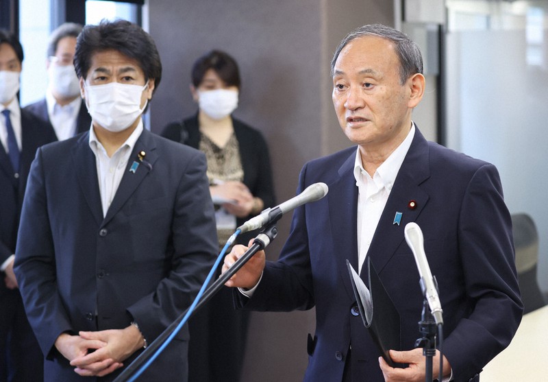 ファストドクターを視察後、報道陣の取材に応じる菅義偉首相。左は田村憲久厚労相=東京都新宿区で2021年9月15日(代表撮影)