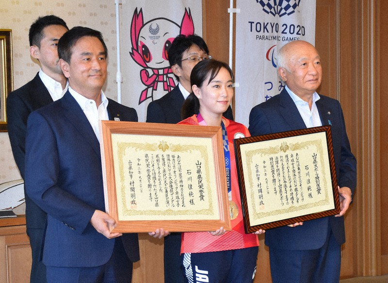 県民栄誉賞を受賞後、村岡知事(手前左)らと記念撮影に臨む石川選手(手前中央)