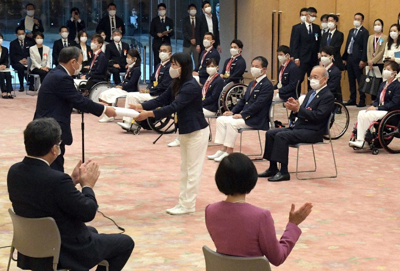 菅義偉首相から記念品を受け取る須崎優衣選手(中央)=首相官邸で2021年9月21日、竹内幹撮影