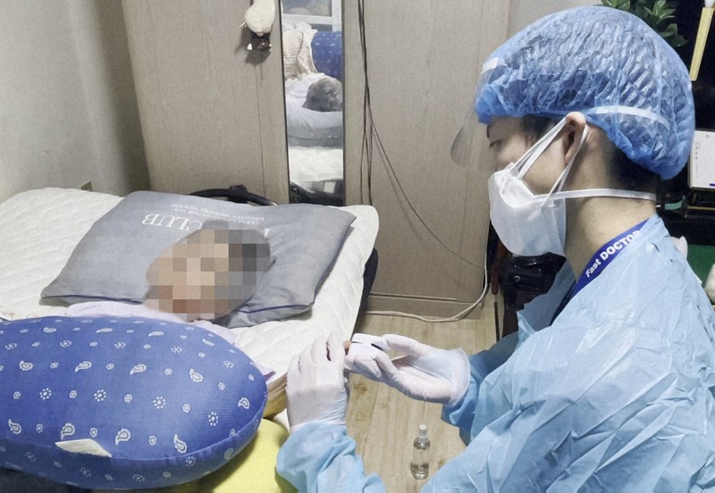 女性患者の血中酸素飽和度を測る笠松大悟医師=大阪府内で9月9日、ファストドクター提供(画像の一部を加工しています)