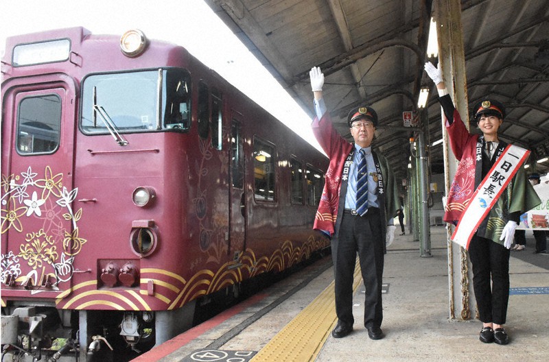観光列車「○○のはなし」を見送る瀧野さん(右)