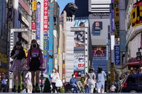 People wearing face masks to protect against COVID-19 walk past a crossing in Shinjuku, an entertainment district of Tokyo, on Sept. 20, 2021. (AP Photo/Kiichiro Sato)