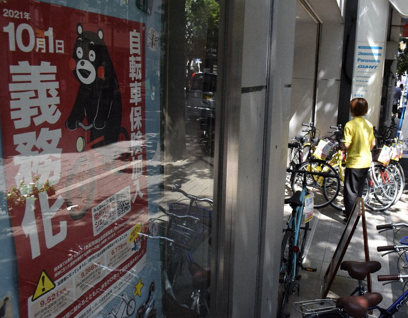 自転車保険の加入を呼び掛けるポスターが貼られた自転車店