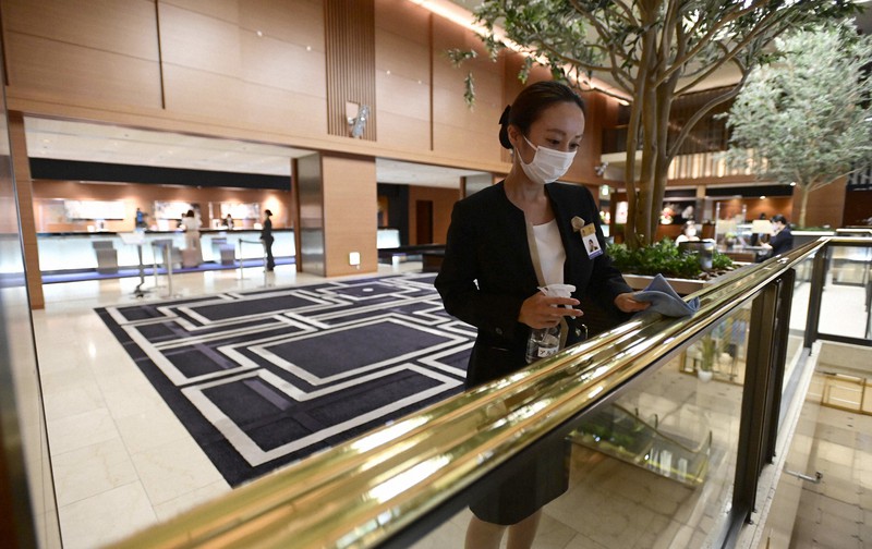 ロビーの手すりを消毒する従業員=大阪市中央区のホテル日航大阪で2021年9月22日、藤井達也撮影