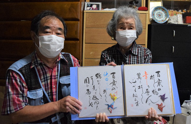 長崎県新上五島町の住民から贈られたお礼の色紙を手にする池田シゲ子さん(右)と司さん=奈良県生駒市で2021年9月22日午後2時2分、塩路佳子撮影