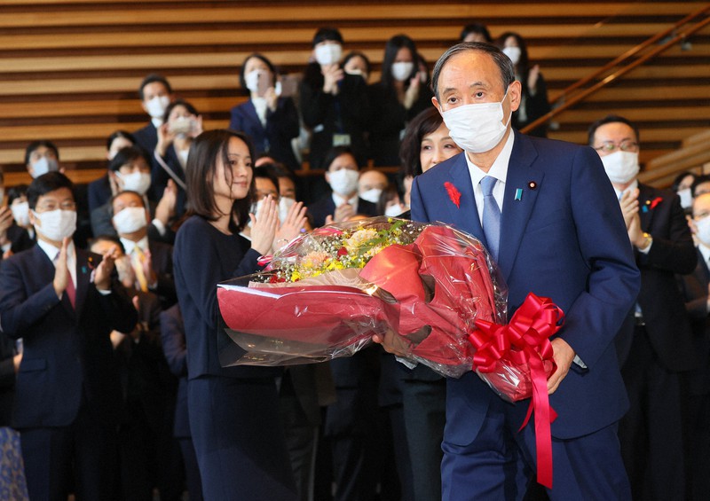 花束を手に首相官邸を後にする菅義偉首相(中央右)=首相官邸で2021年10月4日午後0時33分、宮武祐希撮影