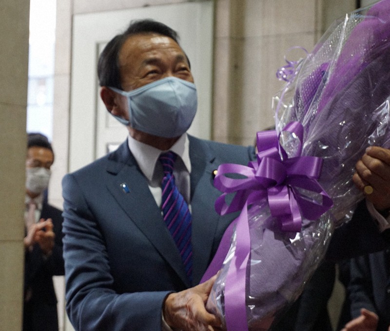 手渡された花束を手に笑顔を見せる麻生太郎前財務相=2021年10月5日(財務省提供)