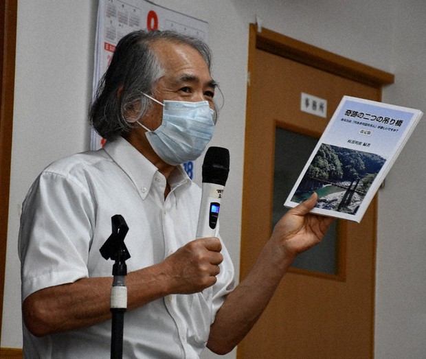 出版記念講演会で本を手にダム反対を訴える岐部さん