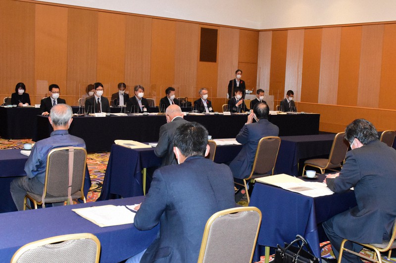 県選管などの担当者ら(奥)から選挙の説明を受ける陣営関係者ら=青森市内で2021年10月8日午後1時34分、平家勇大撮影