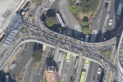 地震の影響で運行が遅れ、JR川口駅（左）の入場規制の解除を待って行列する人々＝埼玉県川口市で2021年10月8日午前8時32分、本社ヘリから梅村直承撮影