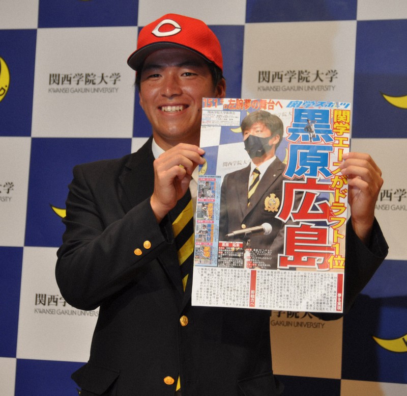 学生が作った号外を手に笑顔を見せる関西学院大の黒原拓未投手=兵庫県西宮市の関西学院会館で2021年10月11日午後6時34分、荻野公一撮影